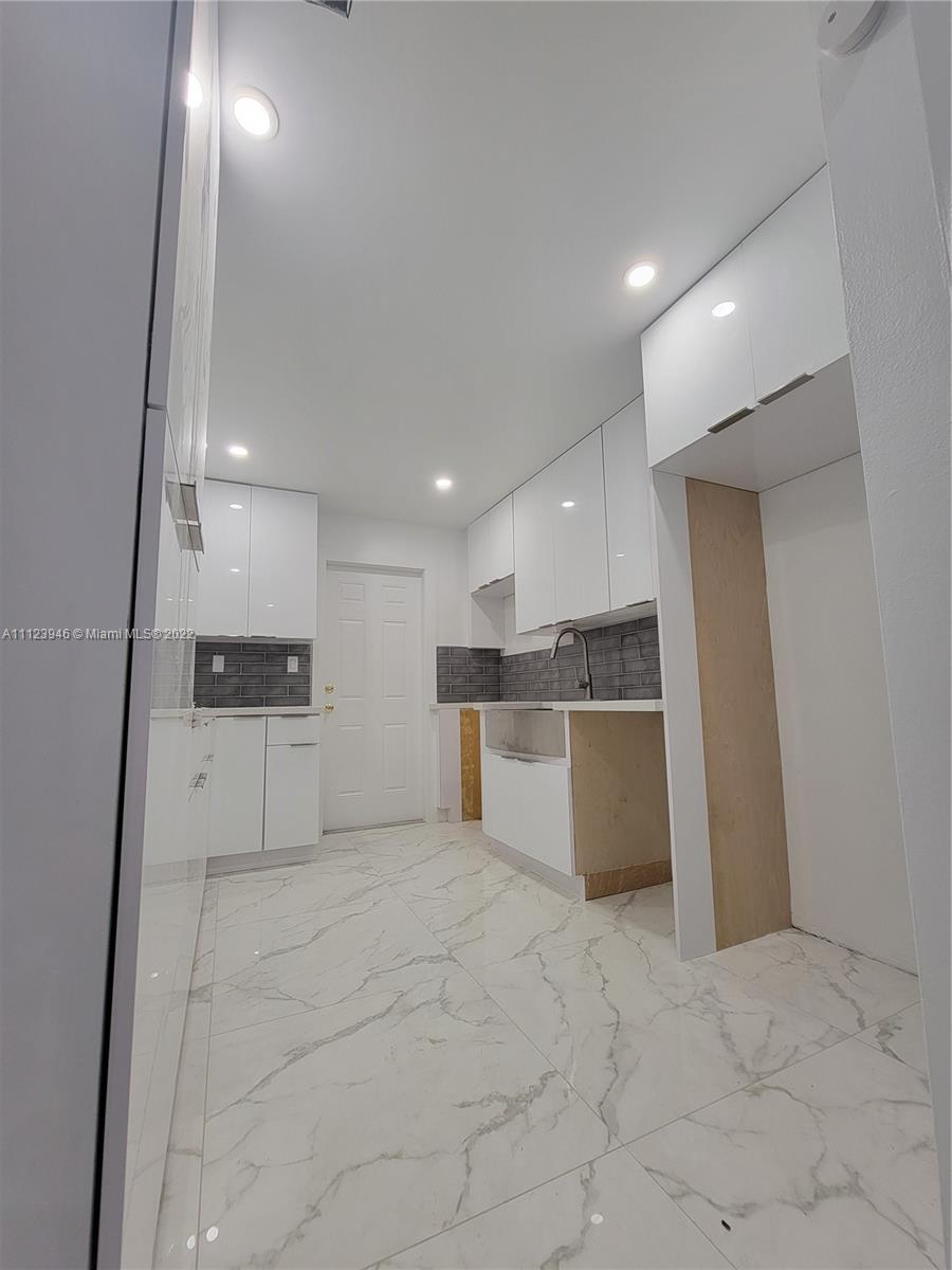 6501 Southwest 34th Street Miami, FL 33155 - Photo 22 of 62 a large white kitchen with kitchen island a sink a stove and a refrigerator
