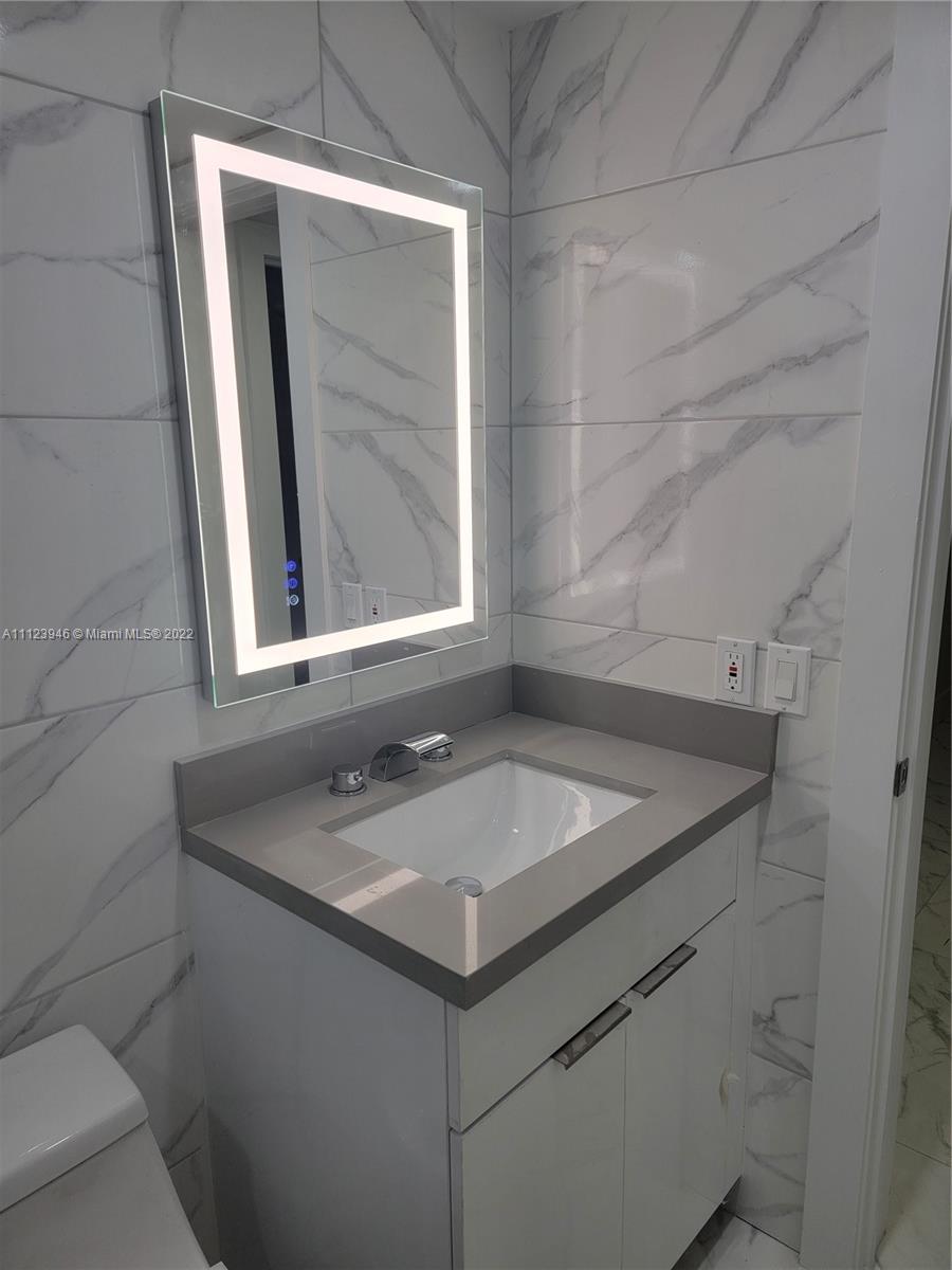 6501 Southwest 34th Street Miami, FL 33155 - Photo 31 of 62 a bathroom with a granite countertop sink and a mirror