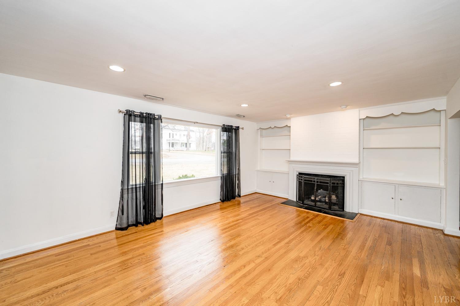 4925 Old Boonsboro Road Lynchburg, VA 24503 - Photo 2 of 57 a view of empty room with a fireplace and wooden floor