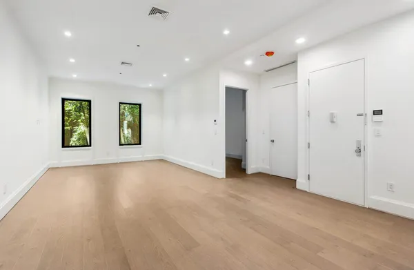 an empty room with windows and closet