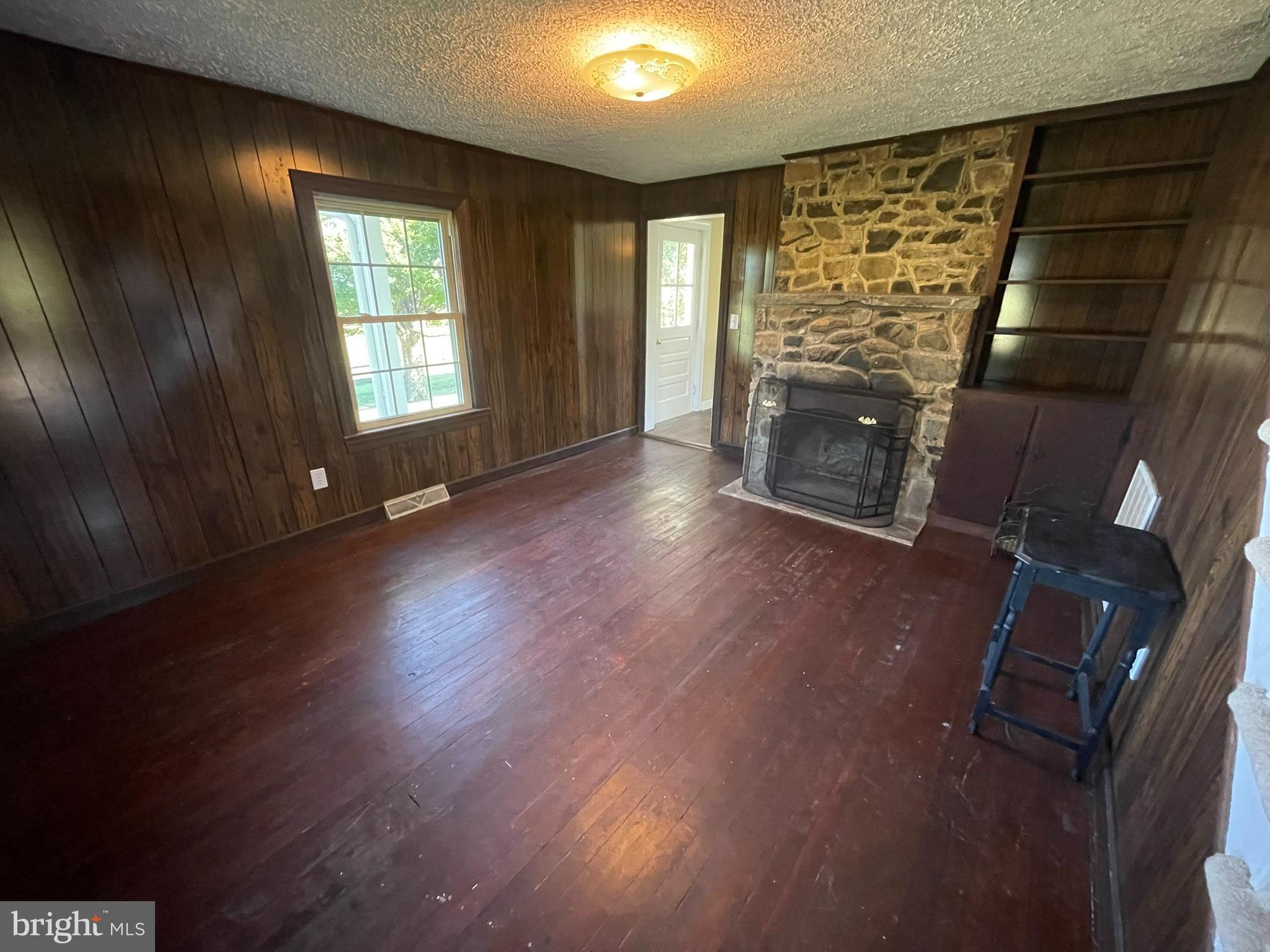 1079 Greystone Road Upperville, VA 20184 - Photo 7 of 21 an empty room with wooden floor fireplace and windows