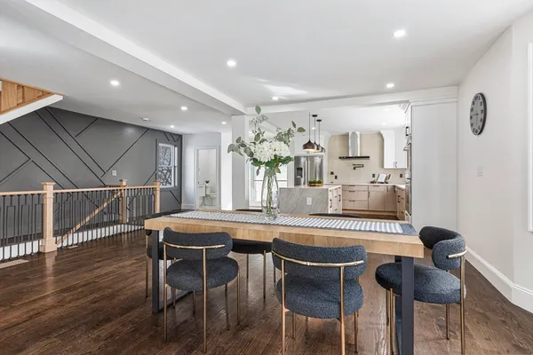 a kitchen with stainless steel appliances kitchen island granite countertop a dining table chairs and granite counter tops