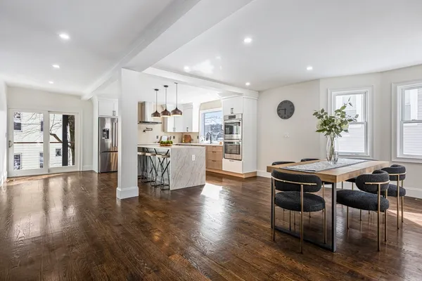 a living room with furniture wooden floor and a kitchen