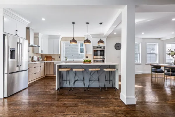 a kitchen with stainless steel appliances a refrigerator a stove top oven and a center island