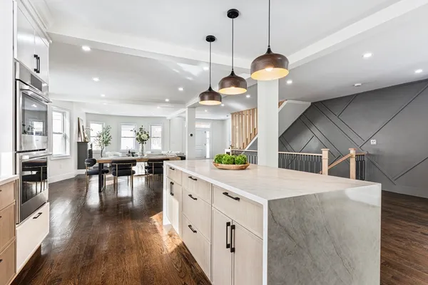 a kitchen with a dining table chairs and wooden floor