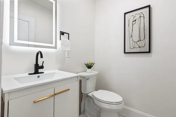 a bathroom with a toilet a sink and mirror