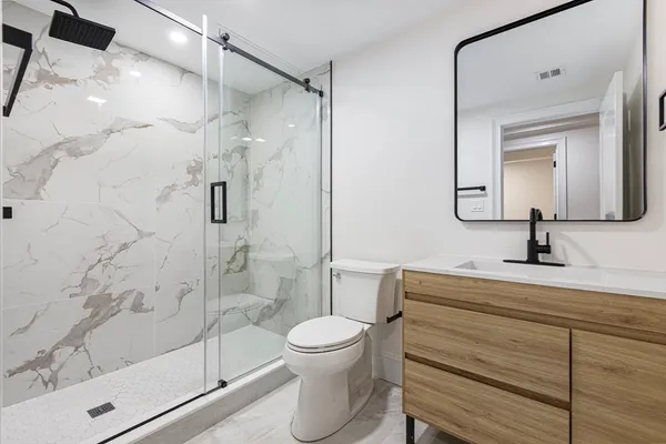 a bathroom with a toilet a sink and shower