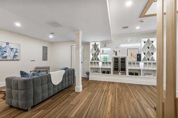 a living room with furniture a flat screen tv and floor to ceiling window