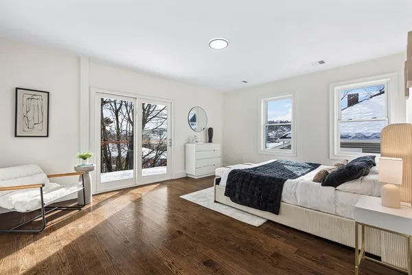 a bedroom with a bed and a table in it with wooden floor