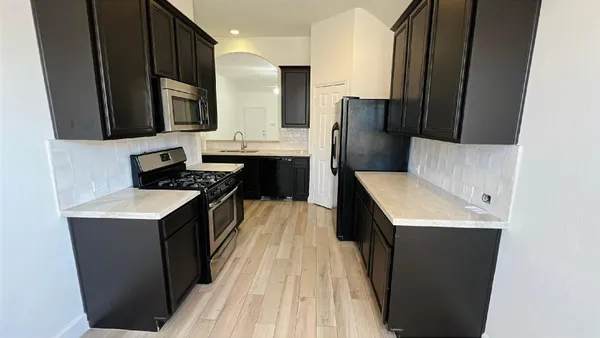 a kitchen with stainless steel appliances a sink stove and refrigerator
