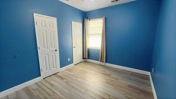 a view of empty room with wooden floor
