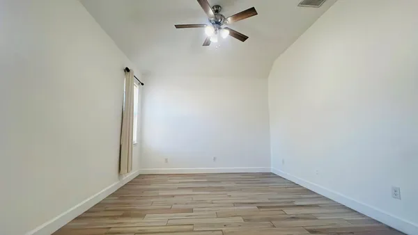 a view of an empty room with wooden floor