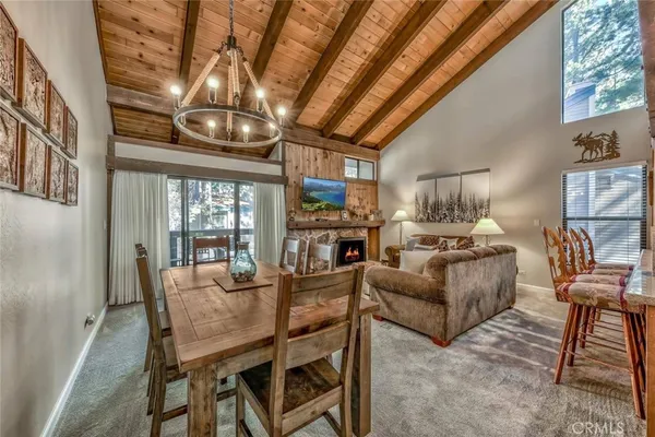 a dining room with furniture a chandelier and wooden floor