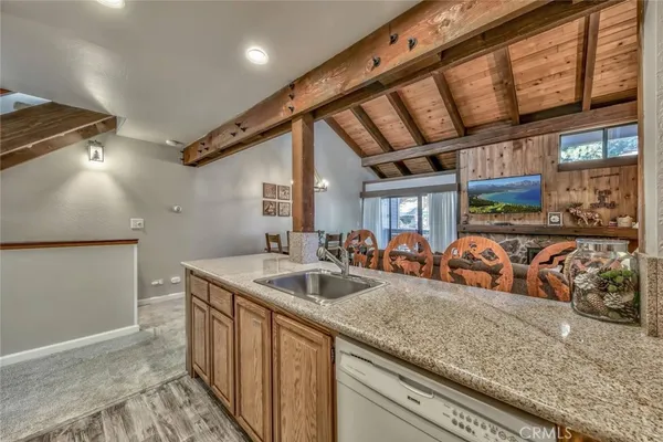 a kitchen with stainless steel appliances granite countertop a sink and wooden cabinets