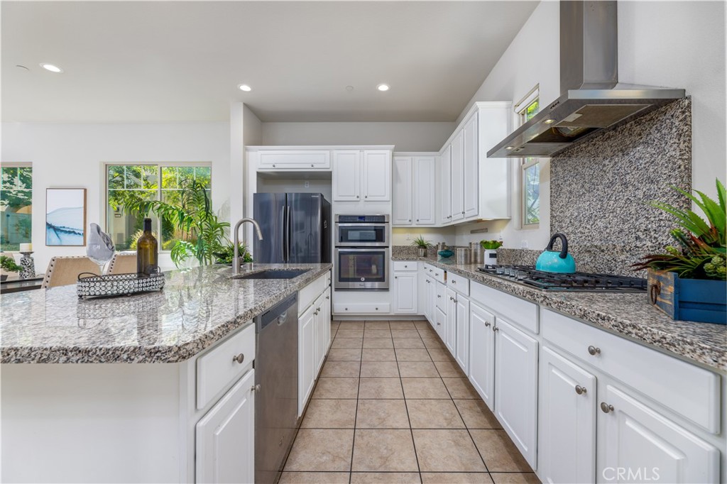 126 Interval Irvine, CA 92618 - Photo 11 of 47 a large kitchen with granite countertop a sink a counter top space appliances and cabinets