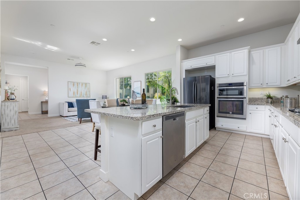 126 Interval Irvine, CA 92618 - Photo 12 of 47 a kitchen with stainless steel appliances kitchen island granite countertop a sink and cabinets