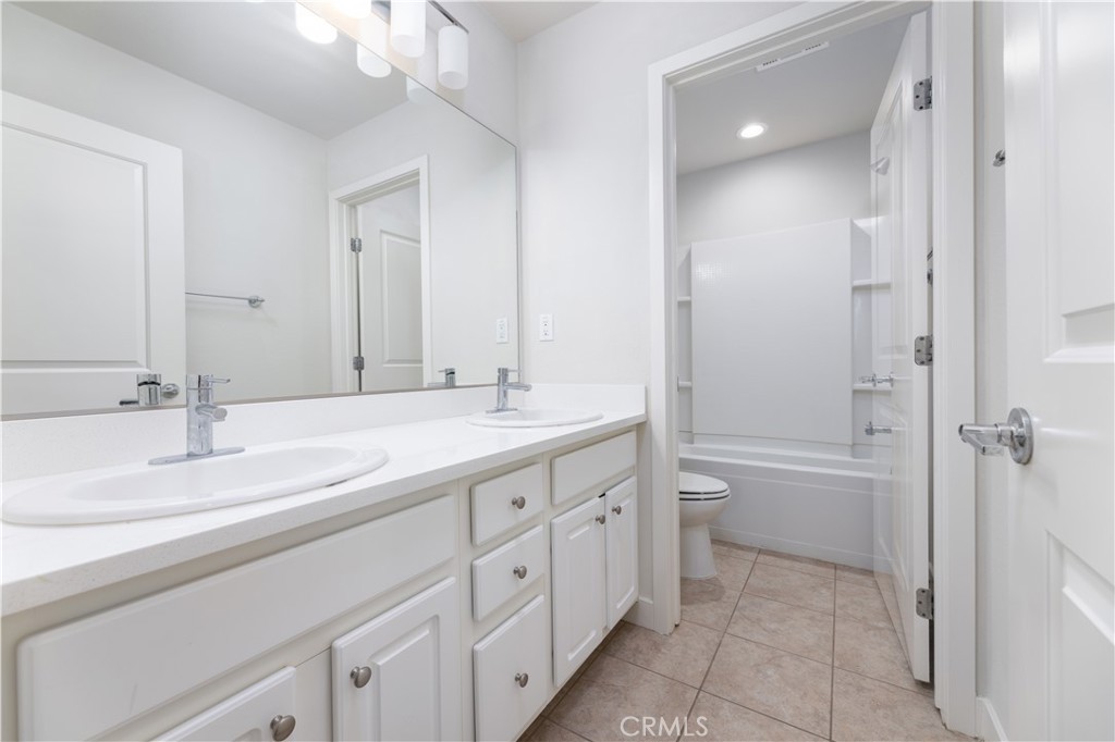 126 Interval Irvine, CA 92618 - Photo 24 of 47 a bathroom with a double vanity sink double mirror bathtub and next to a window