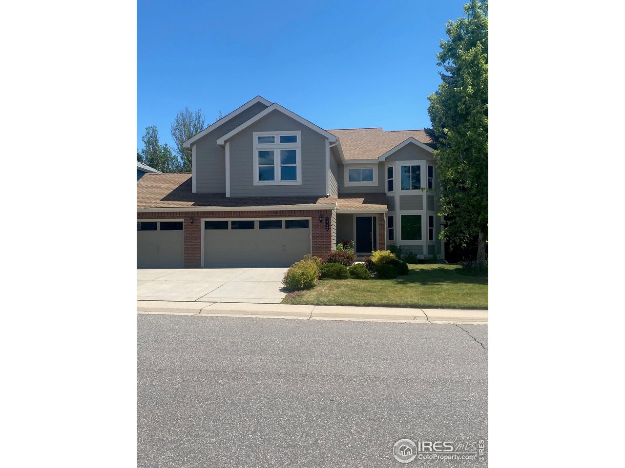 a view of a house with a yard and potted plants