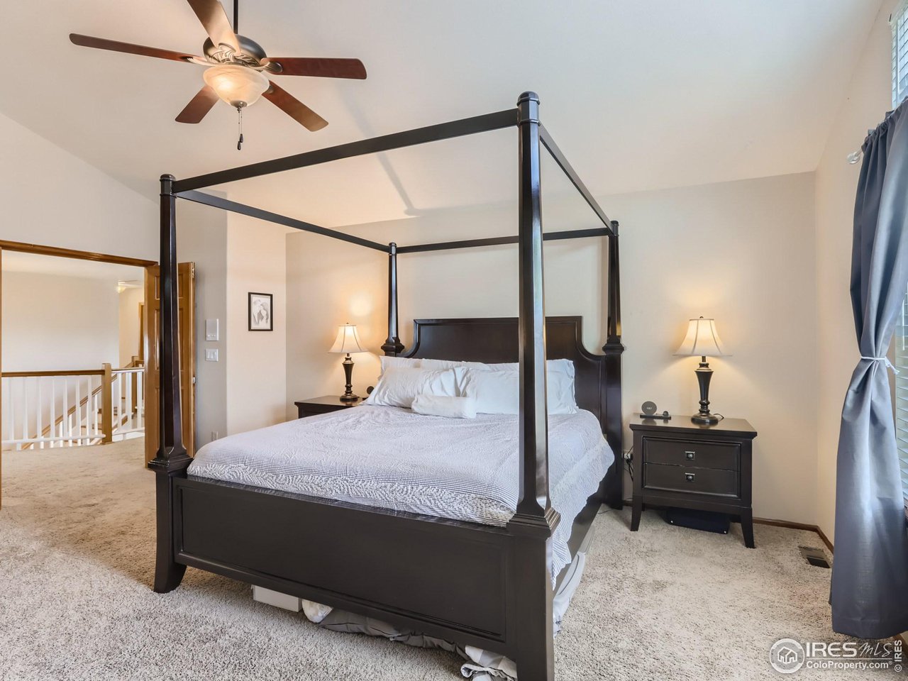 1752 Eldorado Drive Superior, CO 80027 - Photo 15 of 34 a bedroom with a bed a chandelier and a flat tv screen on a dresser