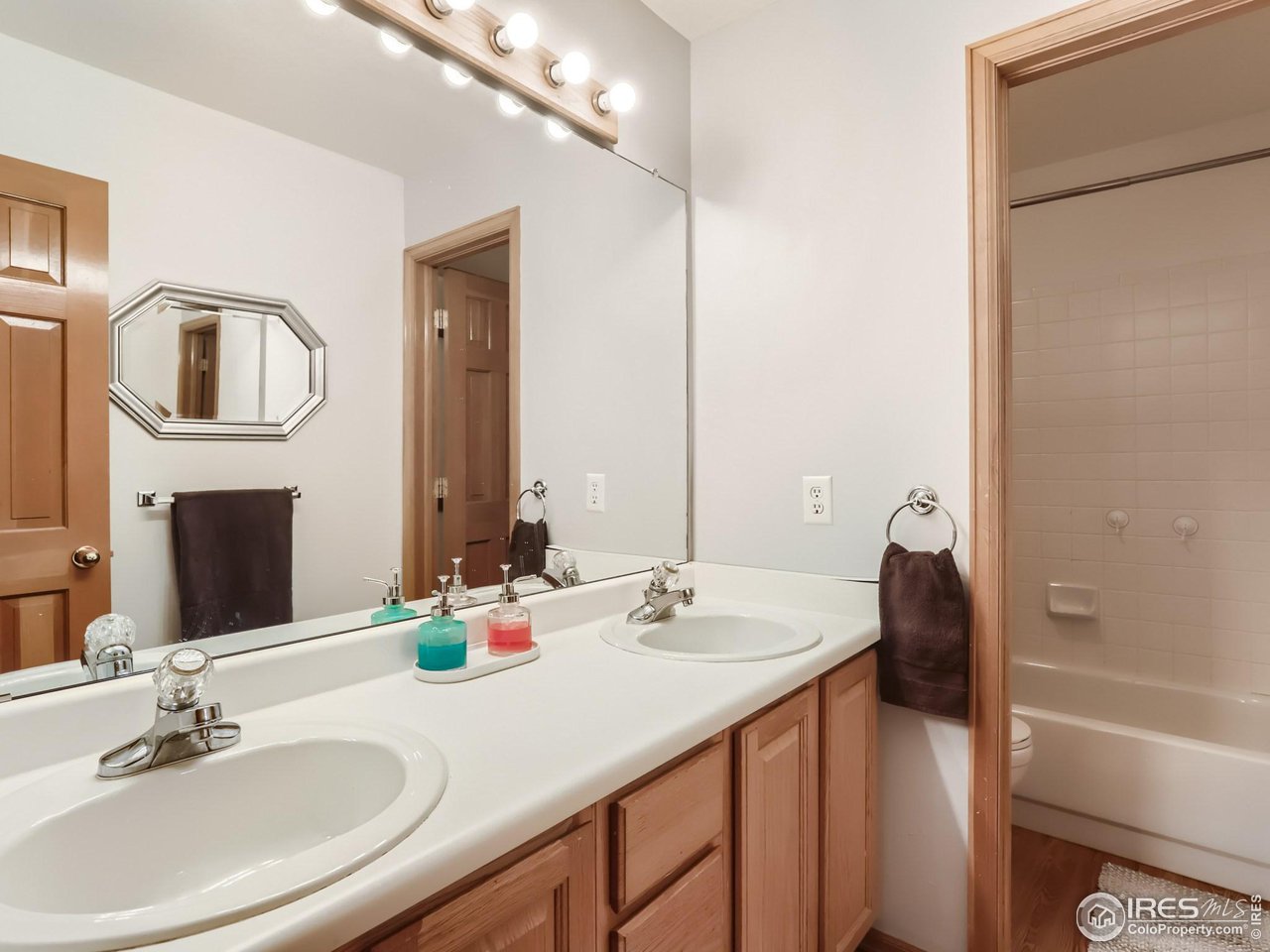 1752 Eldorado Drive Superior, CO 80027 - Photo 20 of 34 a bathroom with a double vanity sink a mirror and a bathtub