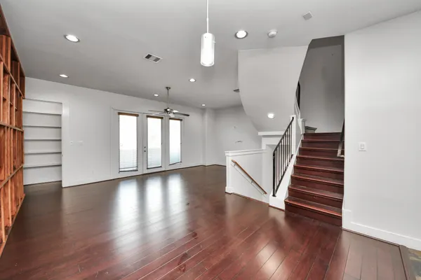 a view of an empty room with a window and wooden floor