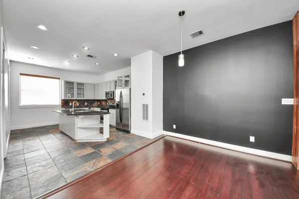 a living room with stainless steel appliances furniture a refrigerator and a window