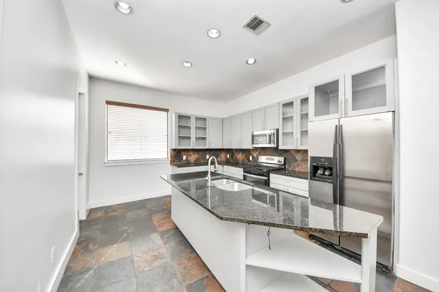 a kitchen with a refrigerator and white cabinets