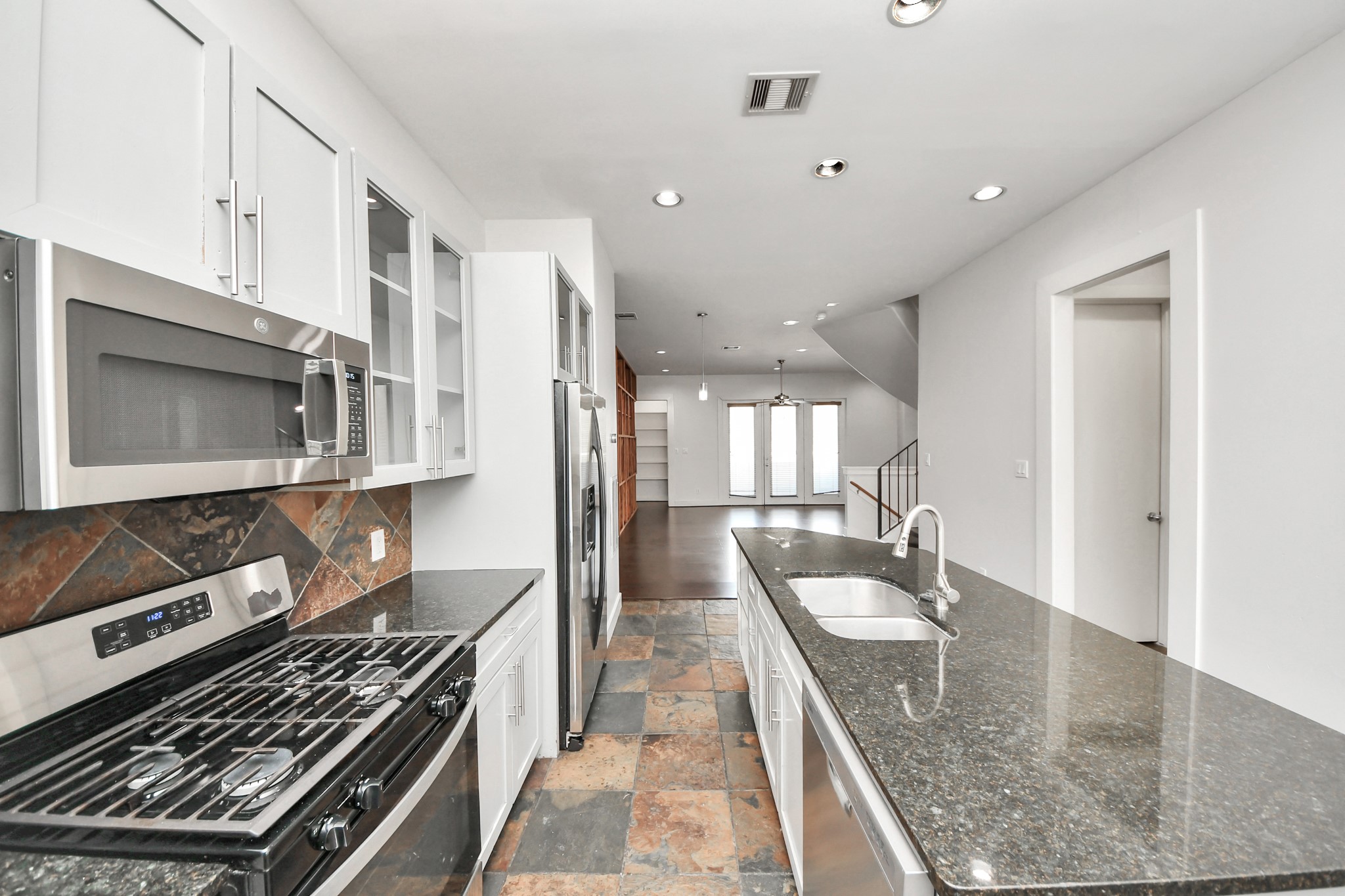 2911 Chartres Street Houston, TX 77004 - Photo 19 of 37 a kitchen with a stove a sink and a microwave