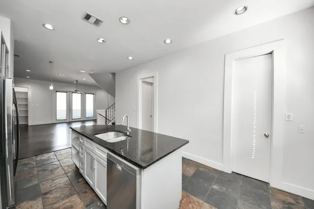 a kitchen with stainless steel appliances granite countertop a sink a stove and a refrigerator