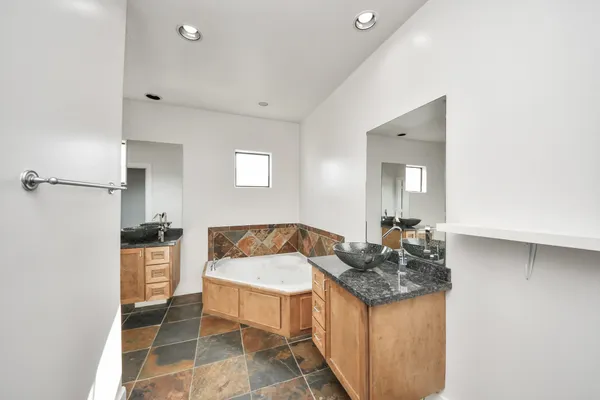 a bathroom with a granite countertop sink and a mirror