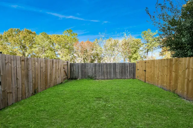 a view of a yard with wooden fence