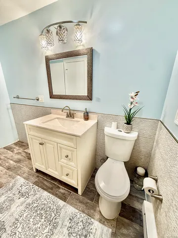 a bathroom with a toilet sink and mirror