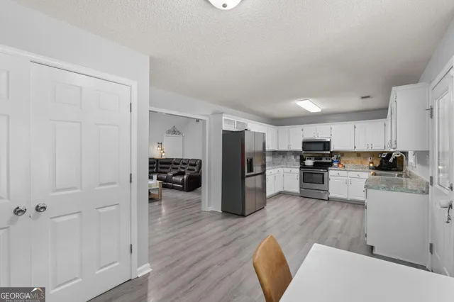 a kitchen with refrigerator and cabinets