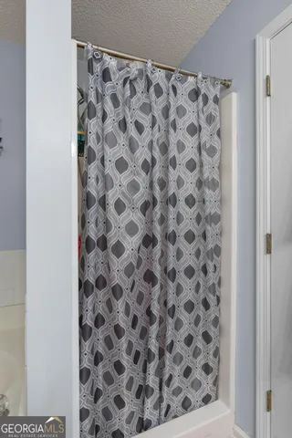 a bathroom with a toilet and a shower curtain