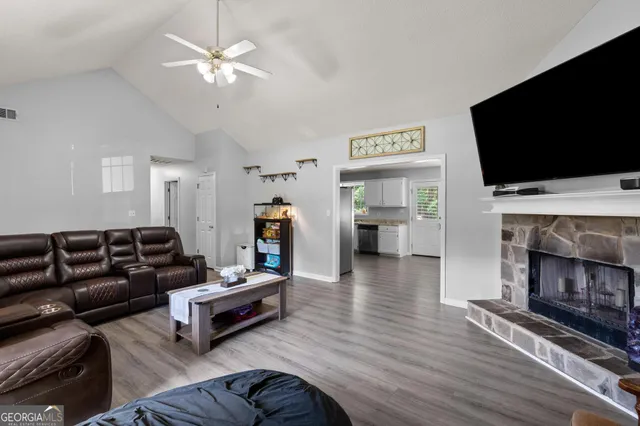 a living room with furniture a flat screen tv and a fireplace