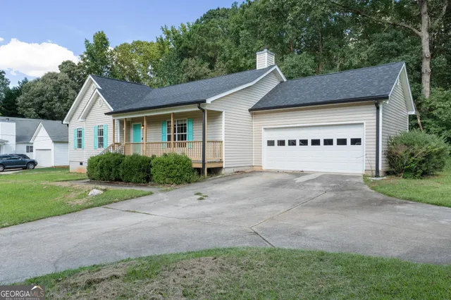 a view of a white house with a yard and large tree