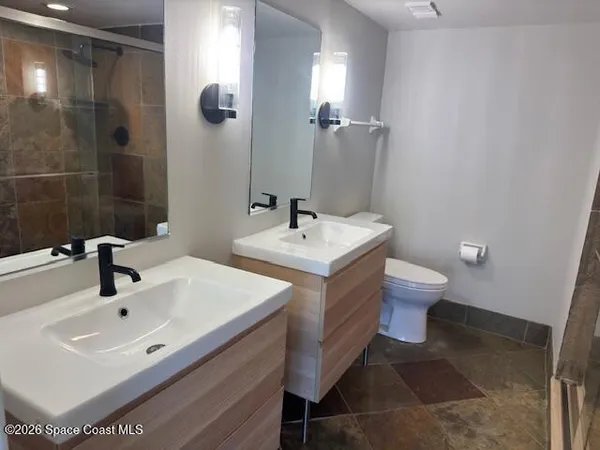a bathroom with a sink a toilet and shower