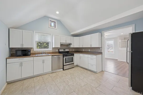 a kitchen with stainless steel appliances granite countertop a stove a sink and a refrigerator