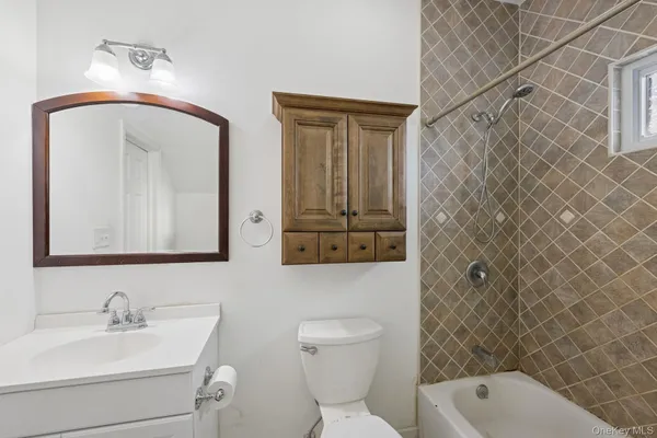 a bathroom with a toilet a sink and mirror
