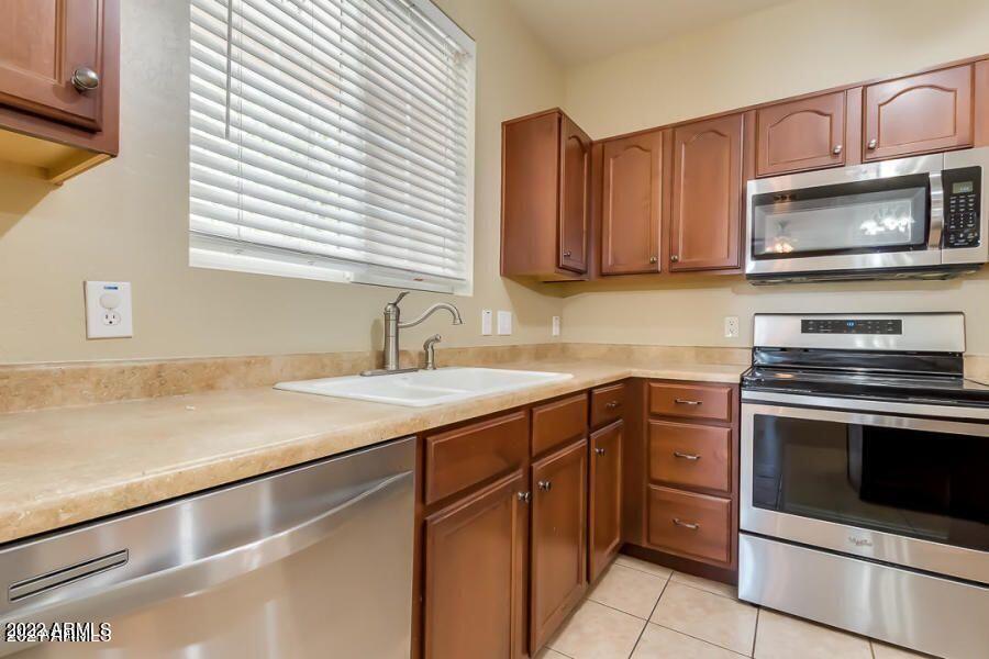 4750 East Thunderheart Trail, Unit 102 Gilbert, AZ 85297 - Photo 11 of 25 a kitchen with a sink stove and microwave