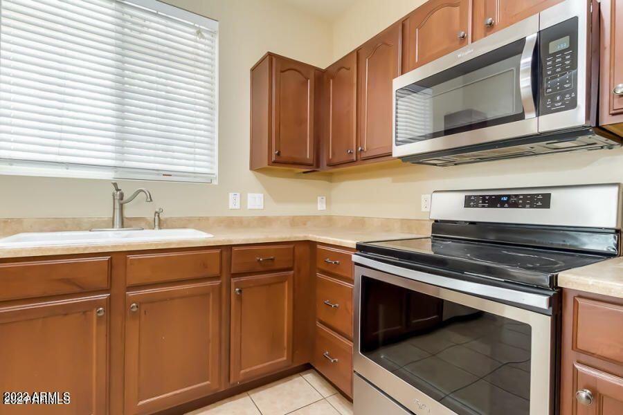 4750 East Thunderheart Trail, Unit 102 Gilbert, AZ 85297 - Photo 12 of 25 a kitchen with cabinets stainless steel appliances and a sink