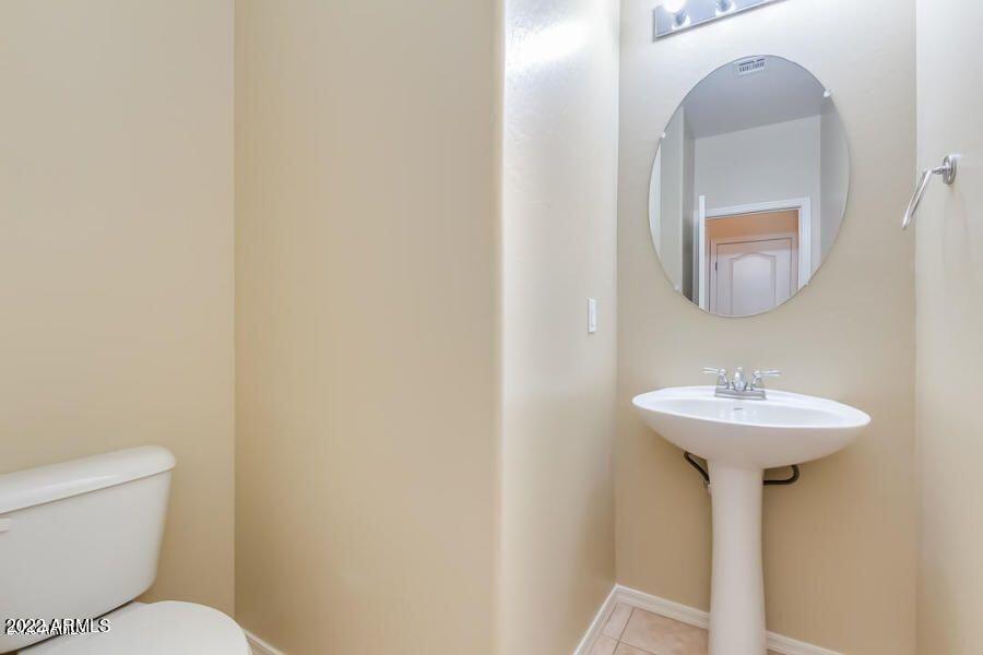 4750 East Thunderheart Trail, Unit 102 Gilbert, AZ 85297 - Photo 13 of 25 a bathroom with a toilet sink and mirror