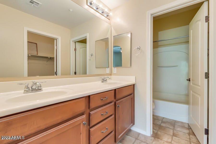 4750 East Thunderheart Trail, Unit 102 Gilbert, AZ 85297 - Photo 18 of 25 a bathroom with a double vanity sink and a mirror