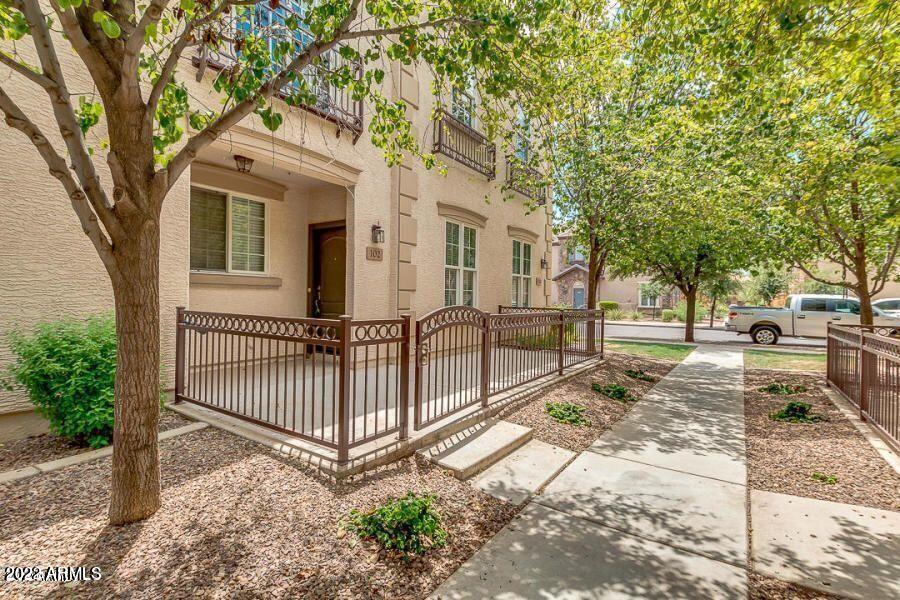 4750 East Thunderheart Trail, Unit 102 Gilbert, AZ 85297 - Photo 3 of 25 a view of a white house with a large tree and wooden fence