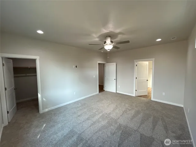a view of an empty room with a chandelier fan