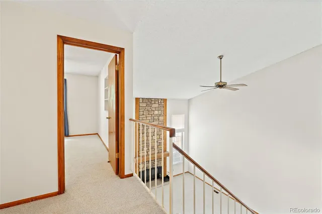 a view of a hallway with wooden floor and staircase