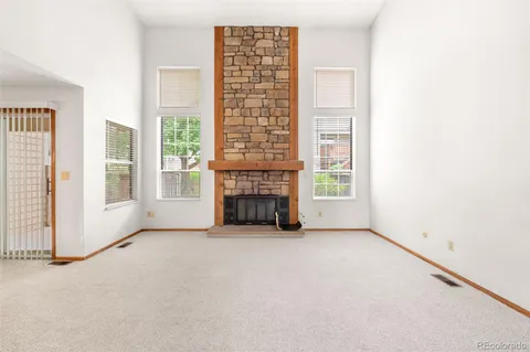 a view of an empty room with a fireplace and a window