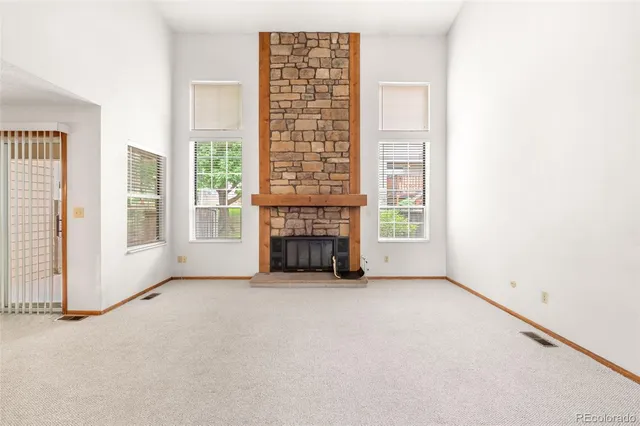 a view of an empty room with a fireplace and a window