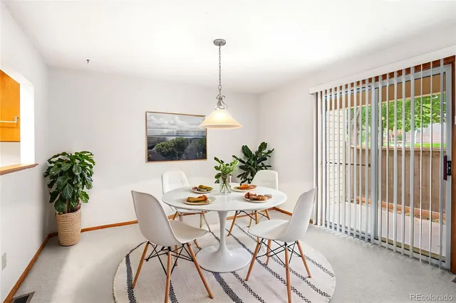 a dining room with furniture potted plants and wooden floor