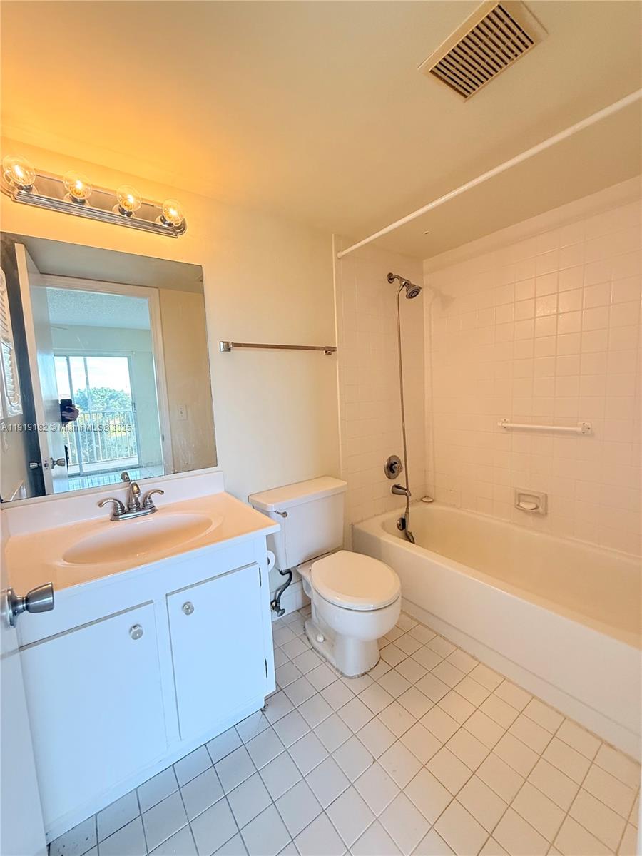 850 Southwest 133rd Terrace, Unit 416B Pembroke Pines, FL 33027 - Photo 12 of 13 a bathroom with a double vanity sink toilet mirror and bathtub